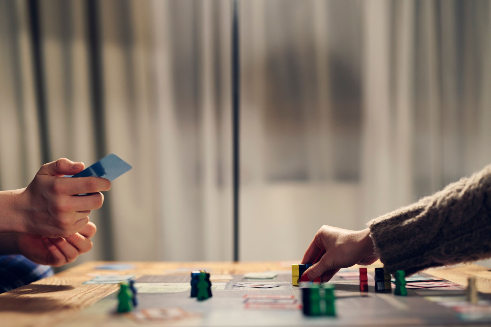 Family playing large modern board game together at home