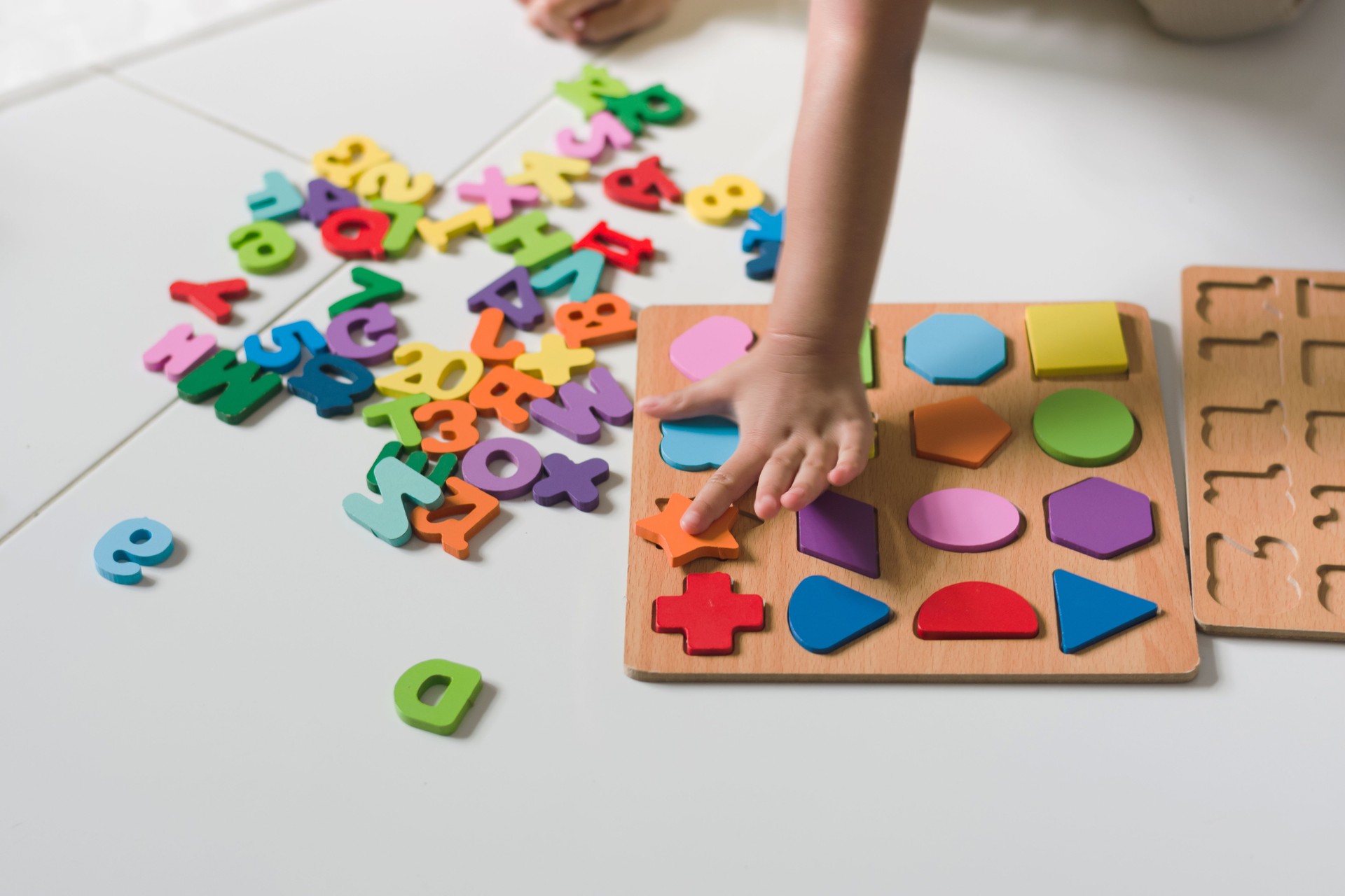 Curious Toddler Playing with Colorful Wooden Puzzle Pieces on the Floor